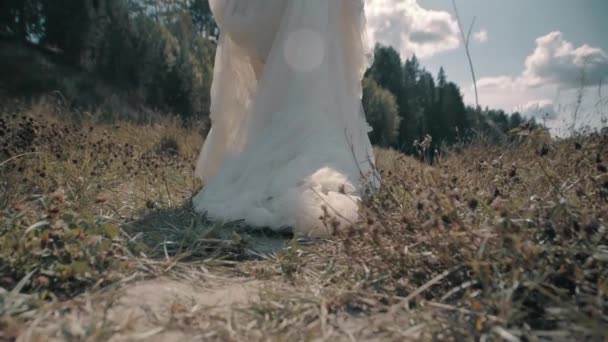 Menina caminha pela floresta e puxa um vestido branco no chão — Vídeo de Stock