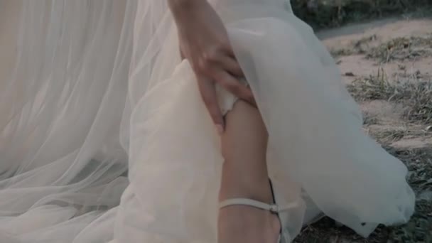 Ragazza bionda in abito bianco seduta vicino al lago — Video Stock