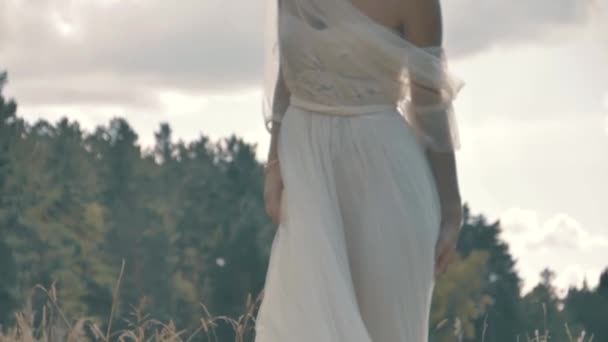 Blonde fille dans une robe blanche assis près du lac 