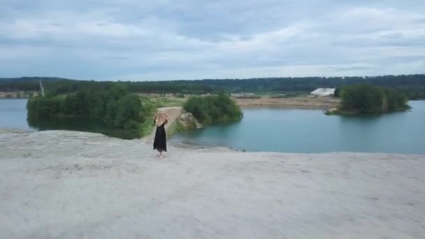 Femme blonde avec robe noire sur la plage de sable — Video