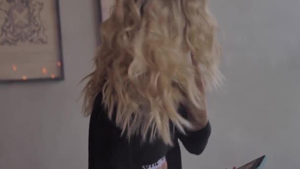Красива молода блондинка в чорній білизні з телефоном — стокове відео