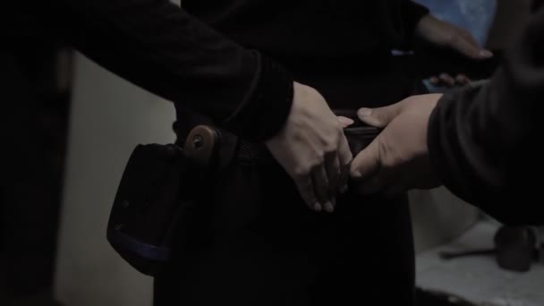 Chica en vestido negro poner en una funda en un cinturón — Vídeos de Stock