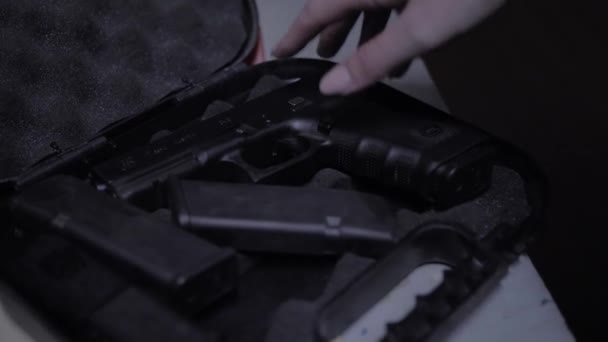 Девушка берёт пистолет из чемодана — стоковое видео