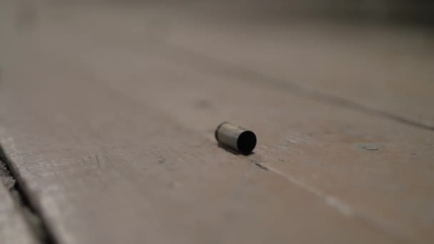 Пустые гильзы лежат на деревянном полу — стоковое видео