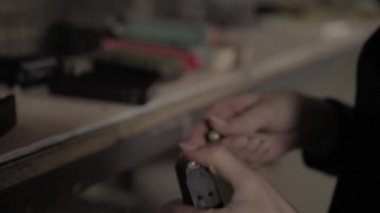 Kız silah şarjörüyle cephane dolduruyor. Glock