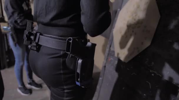 Девушка штукатурка запечатывает отверстия от выстрелов в цель — стоковое видео