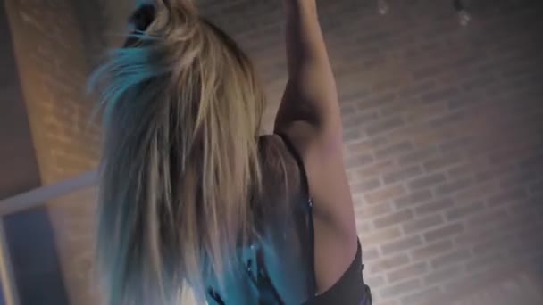 Beautiful young blonde in black underwear brick wall, color lights — Stock Video