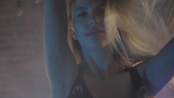 Красивая молодая блондинка в черном белье кирпичная стена, цветные огни — стоковое видео