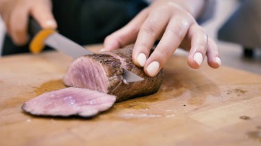 Kız şef bifteği dilimlere ayırıyor.