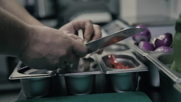 Шеф-повар режет перец и кладет в белый контейнер — стоковое фото