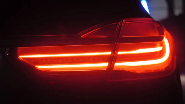 Адаптивная оптика задних фонарей роскошного автомобиля на тёмном фоне — стоковое фото