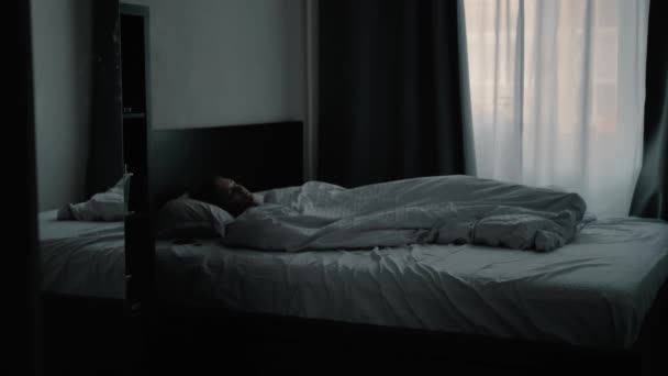 Young beautiful girl waking up in the morning and looks at the phone — Stock Video