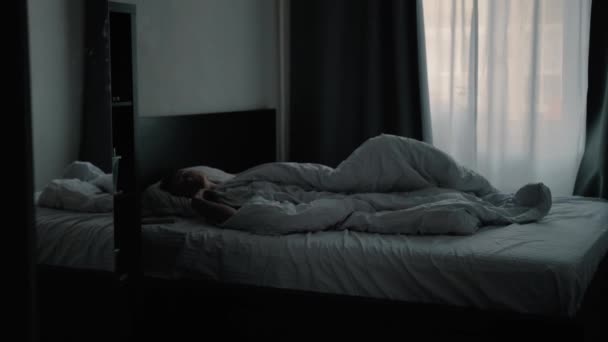 Young beautiful girl waking up in the morning and looks at the phone — Stock Video