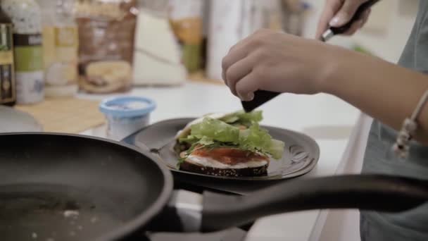 Chica hace sabroso hermoso sándwich saludable con huevo y lechuga — Vídeo de stock