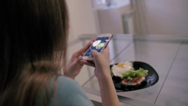 Девушка фотографирует прекрасный сэндвич с завтраком для инстаграма — стоковое видео
