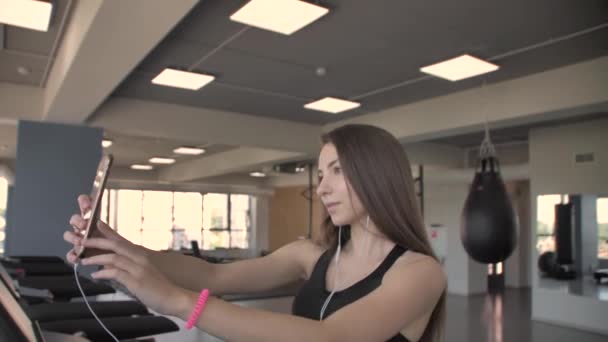 Mooi brunette meisje gefotografeerd zichzelf op de telefoon in de sportschool — Stockvideo