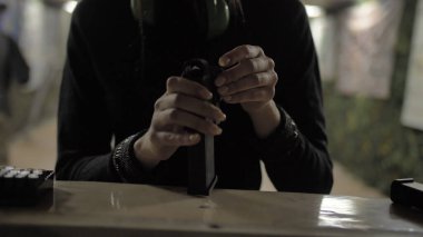 Kız silah şarjörüyle cephane dolduruyor.