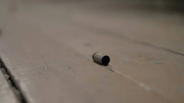 Boîtiers de balle vides reposent sur un plancher en bois — Photo
