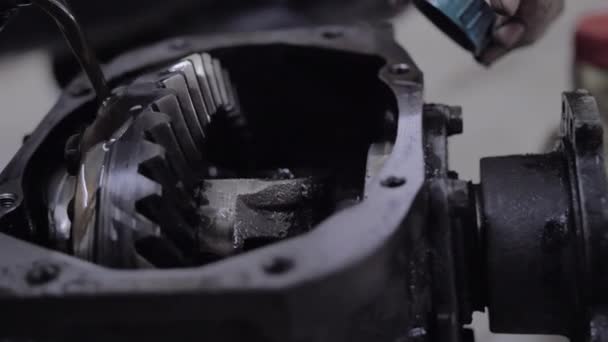 Dark engine oil is poured into the open brewed gearbox — Stock Video