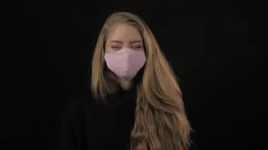 Altın saçlı genç bir kadın pembe bir tıbbi maske takıyor. Siyah arka planda izole edilmiş. Sağlık ve tıbbi konsept. Portreyi kapat. 4 bin. Coronavirus Salgını, Hastalık, Salgın