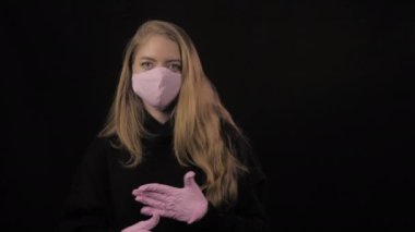 Pembe eldivenli ve maskeli kız eğlen ve yüzünü buruştur. Siyah arka planda izole edilmiş. Sağlık ve tıbbi konsept. Portreyi kapat. 4 bin. Coronavirus Salgını, Hastalık, Salgın