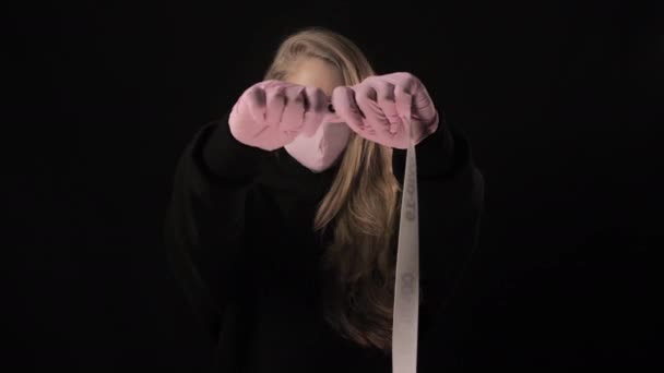 Girl in a pink mask holds a tape with the inscription covid-19. Isolated on black background. Health care and medical concept. Close up portrait . 4k. Coronavirus Epidemic, illness, pandemic — Stock Video