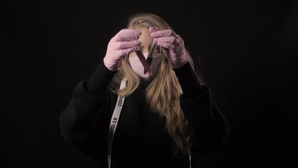 Flicka i svart mask håller ett två provrör med blod och inskriptionen covid-19. Isolerad på svart bakgrund. Sjukvård och medicinskt koncept. Epidemi med coronavirus — Stockvideo