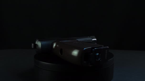Pistola gira sobre una plataforma de fondo negro — Vídeo de stock