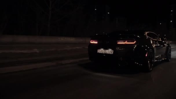 TOMSK, RUSSIA - March 30, 2020: Chevrolet Camaro ZL1 the Exorcist rides on the road at night back view — Stock Video