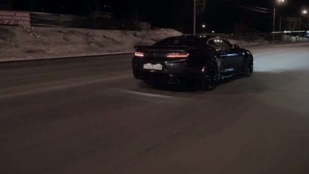 TOMSK, RUSSIE - 30 mars 2020 : Chevrolet Camaro ZL1 l'Exorciste roule sur la route la nuit vue arrière — Video