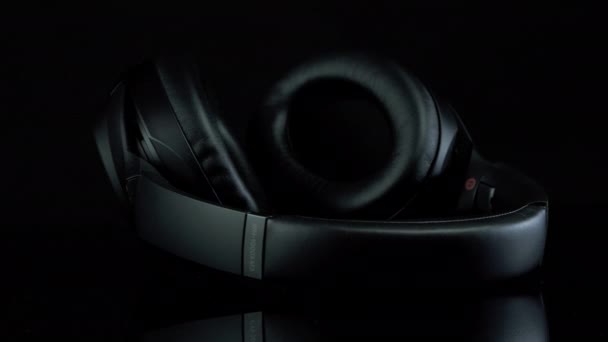 TOMSK, RUSIA - 12 de abril de 2020: Sony WH-1000XM3 Noise Canceling Auriculares inalámbricos sobre una plataforma de rotación de fondo negro. mentiras — Vídeo de stock