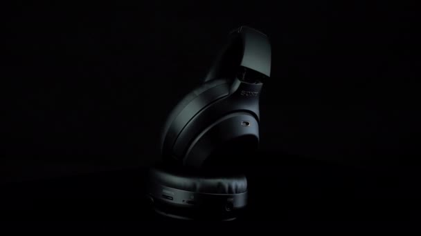 TOMSK, RUSKO - 12. dubna 2020: Sony WH-1000XM3 Hluk Bezdrátová sluchátka na černém pozadí rotační plošiny. Stojící — Stock video