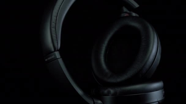 TOMSK, RUSSIA - 12 квітня 2020: Sony WH-1000XM3 Noise Canceling Wireless Headphone на чорному фоні. Стоячи — стокове відео