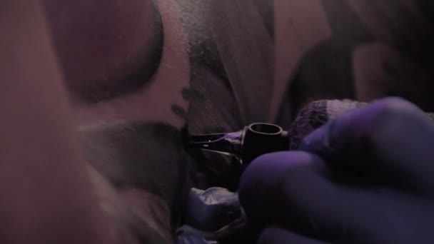 Τατουάζ πλοίαρχος σε μπλε γάντια κάνει ένα τατουάζ, μακροεντολή πυροβόλησε, αργή κίνηση — Αρχείο Βίντεο