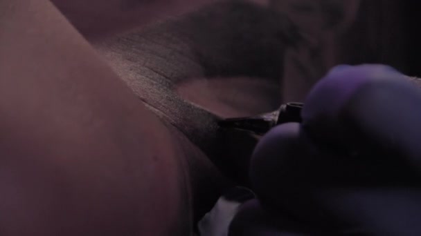 Tattoo meester in blauwe handschoenen maakt een tatoeage, macro shot, slowmotion — Stockvideo