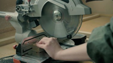 Atölyede ahşap malzemeler kesen bir kız.