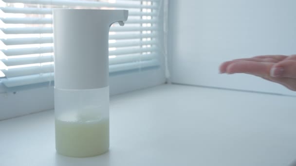 Ragazza che utilizza distributore automatico di sapone schiuma, lavarsi le mani, chiudere, macro, sul davanzale della finestra — Video Stock