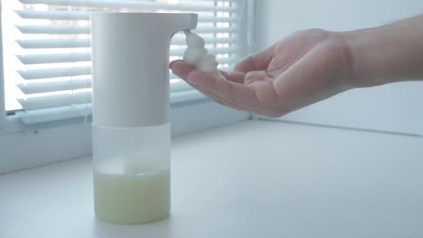 Homme utilisant distributeur automatique de savon mousse, se laver les mains, fermer, macro, sur le rebord de la fenêtre — Video