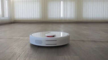 Linolyum ahşap zemin üzerinde beyaz robotik süpürge akıllı temizlik teknolojisi