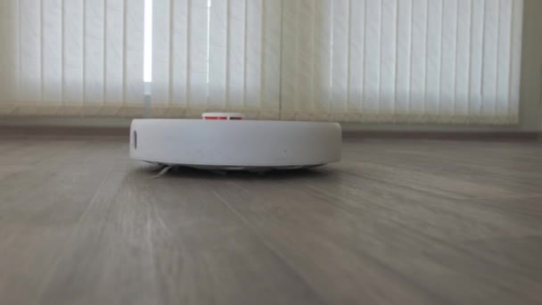 Aspiradora robótica blanca en suelo de madera linóleo tecnología de limpieza inteligente — Vídeos de Stock