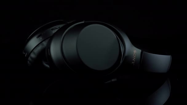 TOMSK, RUSSIE - 12 avril 2020 : Sony WH-1000XM3 Noise Canceling Casques sans fil sur un fond noir de plate-forme de rotation — Video