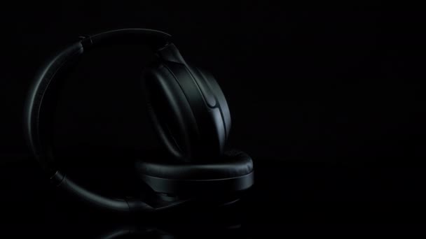 TOMSK, RUSLAND - 12 april 2020: Sony WH-1000XM3 Noise Canceling Draadloze hoofdtelefoon op een rotatieplatform zwarte achtergrond — Stockvideo