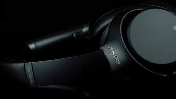 TOMSK, RUSIA - 12 de abril de 2020: Sony WH-1000XM3 Noise Canceling Auriculares inalámbricos sobre una plataforma de rotación de fondo negro. De cerca. —  Fotos de Stock