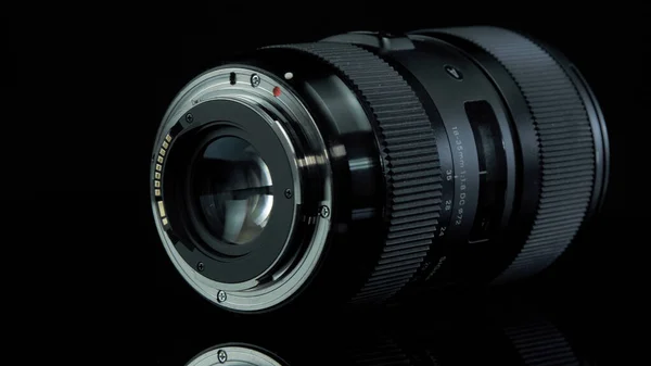 TOMSK, RUSKO - 12. dubna 2020: Sigma 18-35mm F 1.8 DC HSM Art Objektiv pro Canon, rotační plošina, černé pozadí — Stock fotografie