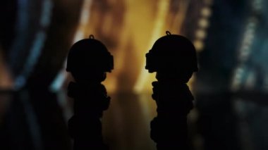 TOMSK, RUSSIA - 21 Mayıs 2020: PUBG oyunundan tüfekli iki küçük adam renk arkaplanına karşı bir masada duruyor. Siluet