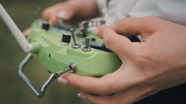 Yakın plan kadın elleri FPV yarış insansız hava aracının uzaktan kumanda çubukları