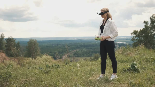 Kız İHA 'yı kontrol etmek için siyah FPV gözlükleri takıyor.