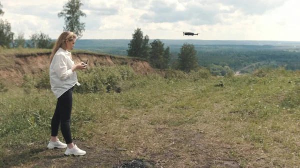 TOMSK, RUSIA - 23 de mayo de 2020: DJI Mavic Pro drone flotando en el aire y la niña en el fondo —  Fotos de Stock
