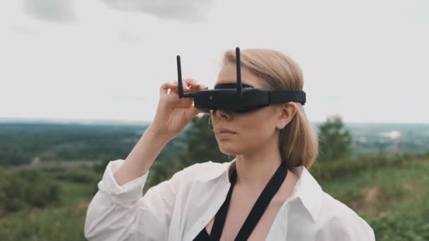 Meisje in zwart FPV bril en een race drone bedieningspaneel — Stockvideo