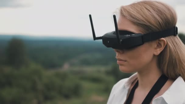 Fille en noir lunettes FPV et un panneau de contrôle de drone de course — Video